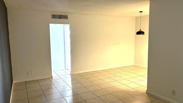 tiled spare room with a textured ceiling