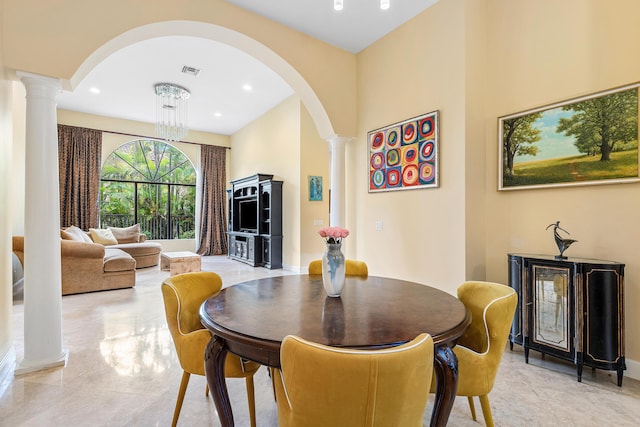 dining room with ornate columns and a notable chandelier