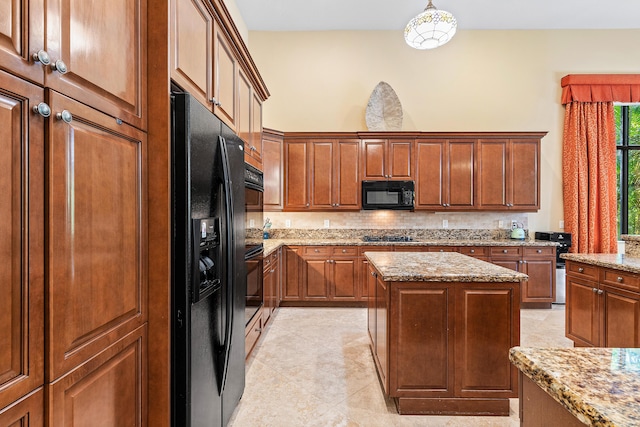 kitchen featuring light stone countertops, a kitchen island, pendant lighting, light tile patterned flooring, and black appliances