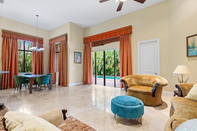 living room featuring ceiling fan with notable chandelier and plenty of natural light