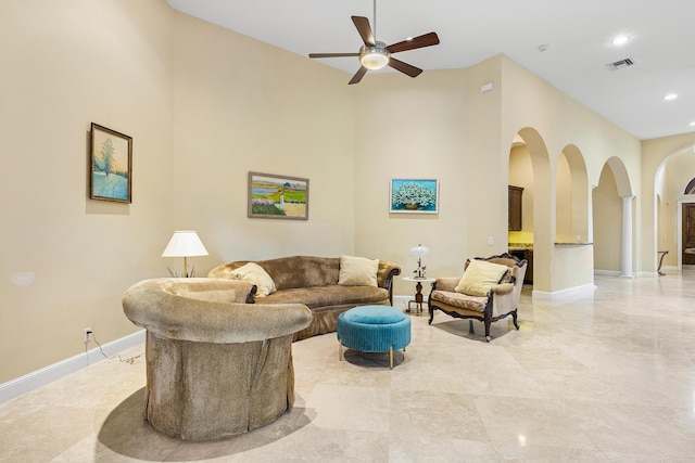 living room with ceiling fan and a high ceiling