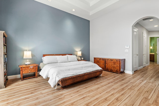 bedroom featuring ensuite bath and light hardwood / wood-style flooring