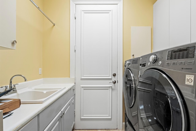 laundry area with washing machine and clothes dryer, sink, and cabinets