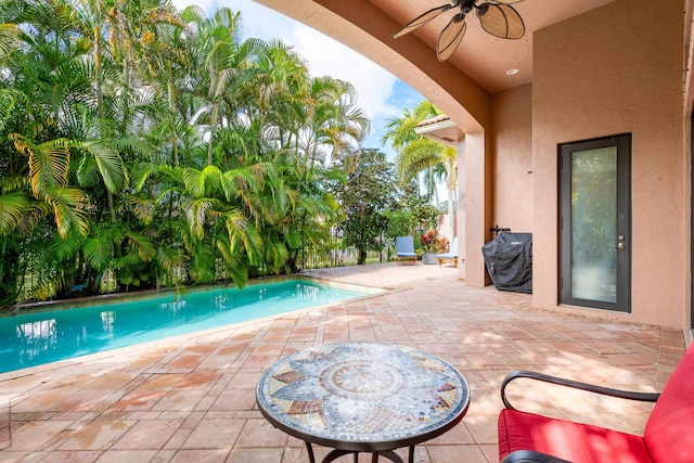 view of pool with a patio area, ceiling fan, and grilling area