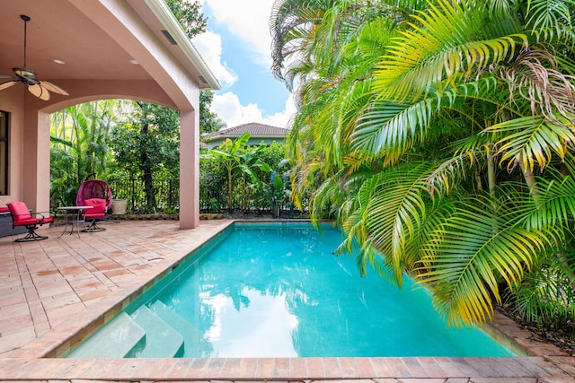 view of pool with a patio and ceiling fan