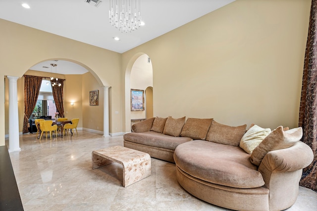 living room featuring decorative columns and a chandelier