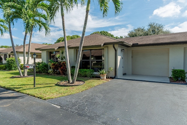 ranch-style house featuring a garage and a front lawn