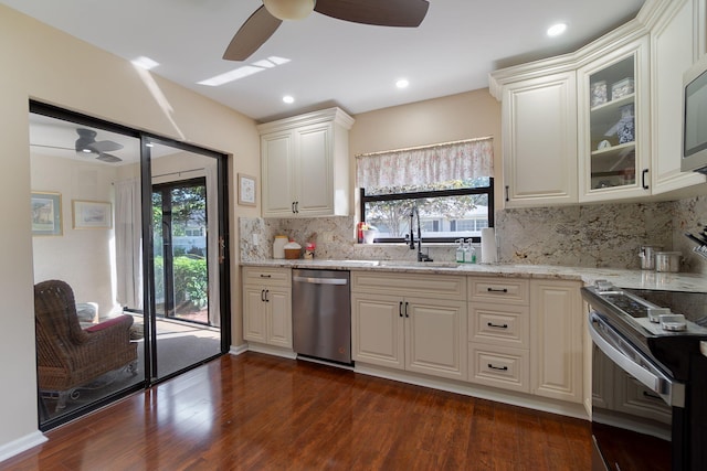 kitchen featuring appliances with stainless steel finishes, sink, backsplash, white cabinetry, and dark hardwood / wood-style floors