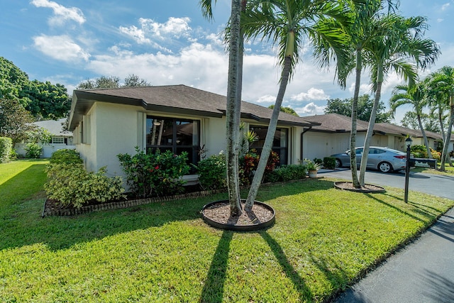 single story home with a front yard and a garage