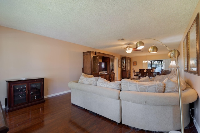 living room featuring a textured ceiling, dark hardwood / wood-style floors, and ceiling fan