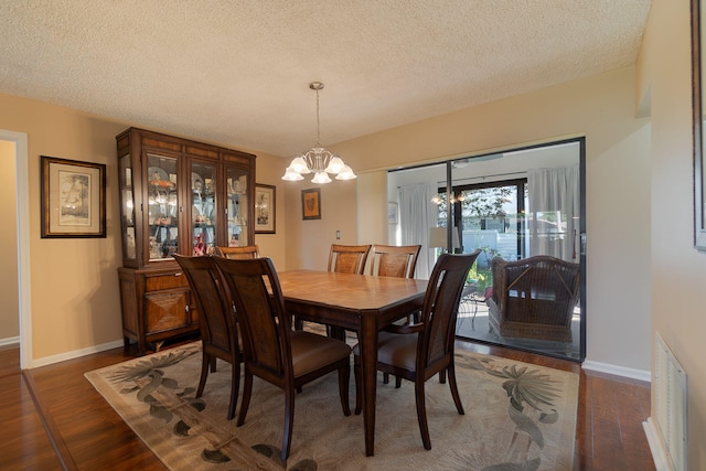 dining space featuring a textured ceiling and dark hardwood / wood-style floors