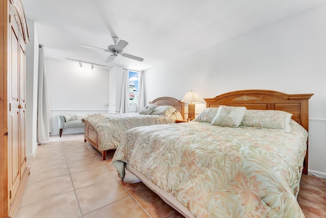 bedroom featuring a closet, track lighting, light tile patterned floors, and ceiling fan