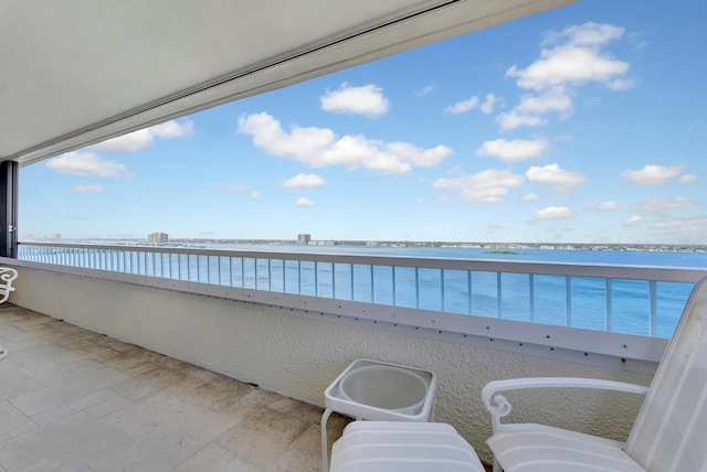 view of patio with a balcony and a water view