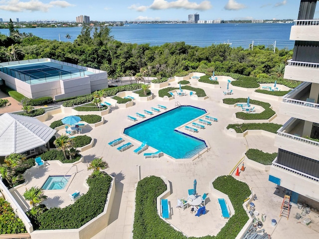 view of pool with a patio and a water view