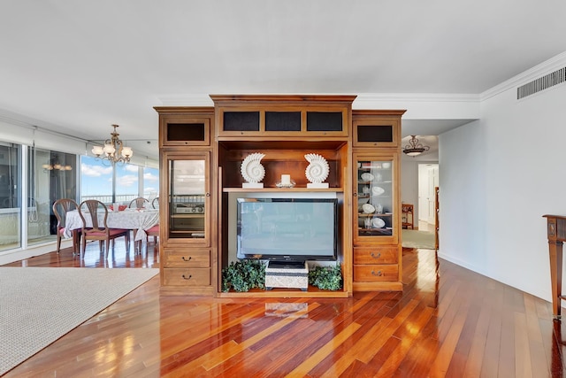 living room featuring ornamental molding, an inviting chandelier, and hardwood / wood-style floors