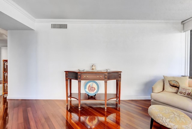 sitting room with dark wood-type flooring and ornamental molding