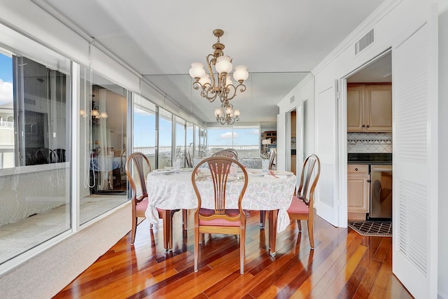 dining space featuring hardwood / wood-style floors and a notable chandelier