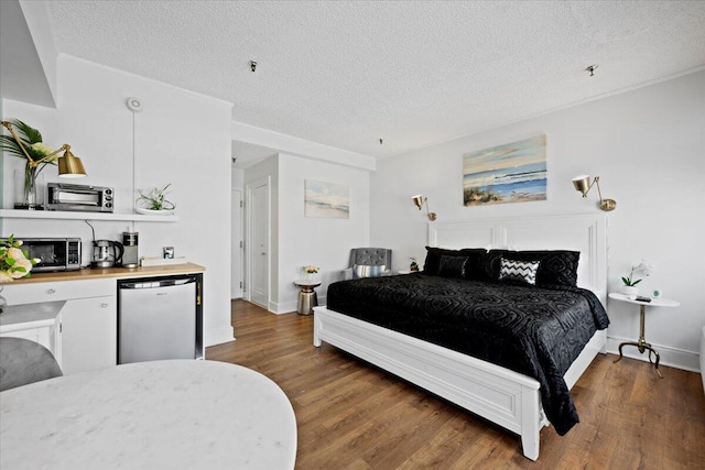 bedroom with dark hardwood / wood-style floors and a textured ceiling