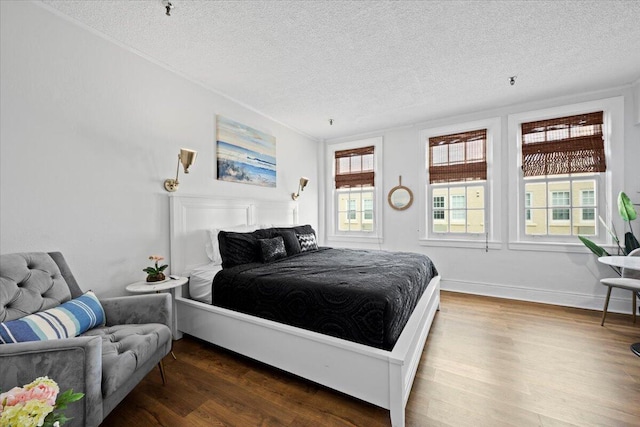 bedroom with dark hardwood / wood-style floors and a textured ceiling