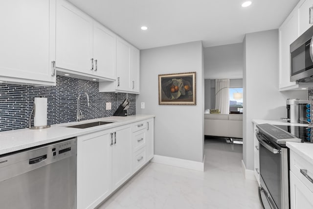 kitchen featuring stainless steel appliances, tasteful backsplash, sink, and white cabinets