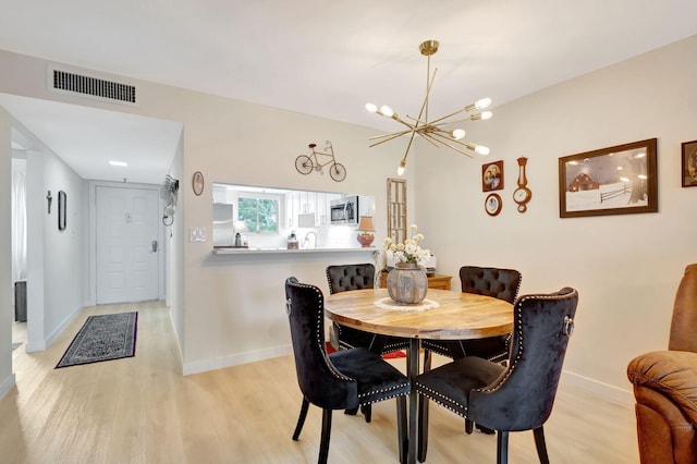 dining space featuring a chandelier and light wood-type flooring