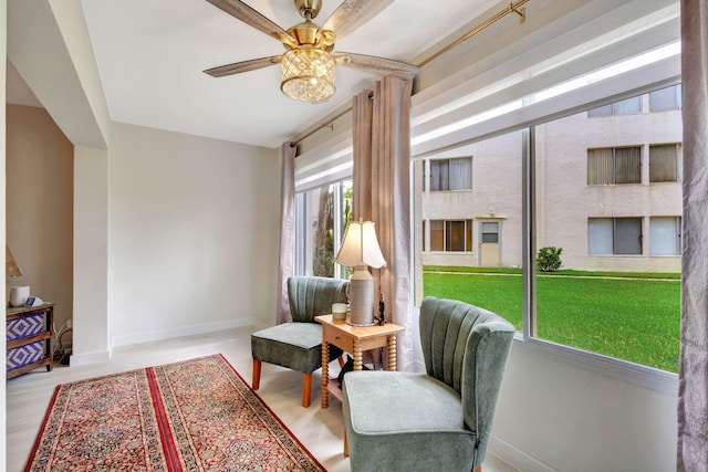 living area with light hardwood / wood-style floors and ceiling fan