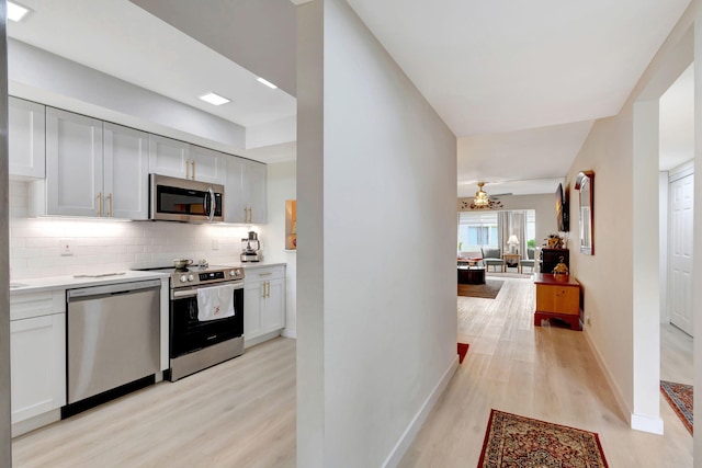 kitchen featuring appliances with stainless steel finishes, white cabinetry, backsplash, and light hardwood / wood-style floors