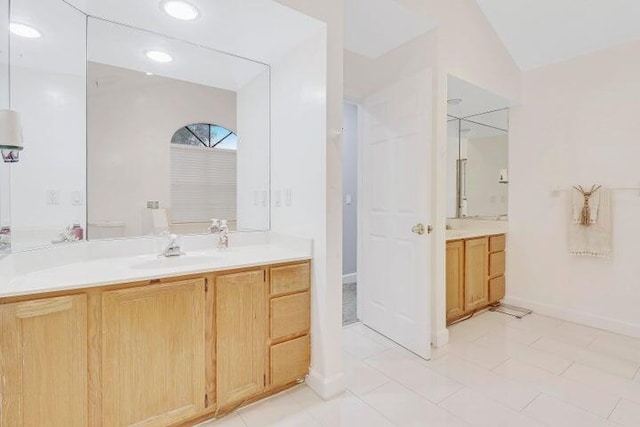 bathroom featuring lofted ceiling, tile patterned floors, toilet, and vanity