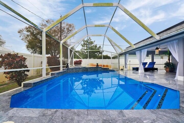 view of pool featuring glass enclosure and a patio area