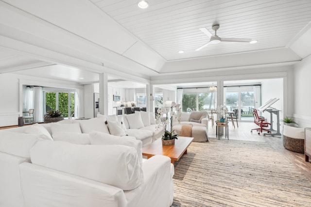 living room featuring wood-type flooring, wooden ceiling, ceiling fan, and plenty of natural light