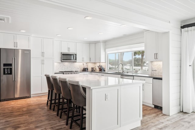 kitchen with white cabinets, a kitchen island, and appliances with stainless steel finishes