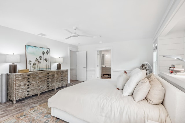 bedroom featuring ceiling fan, ensuite bath, and wood-type flooring