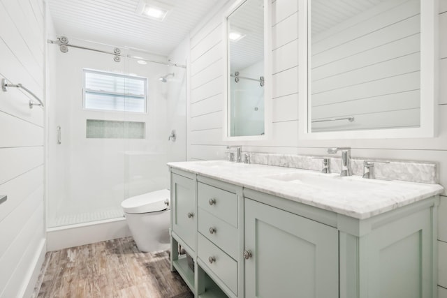 bathroom with toilet, vanity, hardwood / wood-style flooring, and a shower with shower door