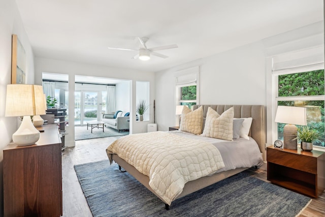 bedroom featuring multiple windows, wood-type flooring, and ceiling fan