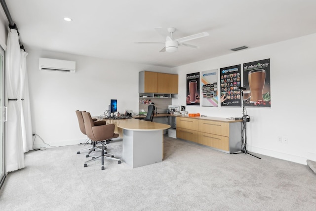 office space with a wall unit AC, ceiling fan, built in desk, and light colored carpet