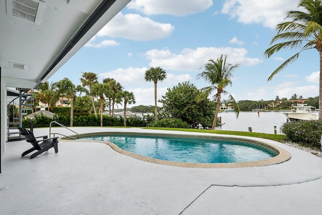 view of swimming pool featuring a patio area and a water view