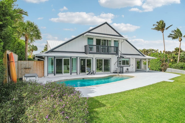 back of house with a balcony, a lawn, a fenced in pool, and a patio area