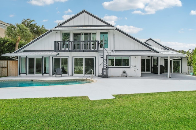 back of house featuring a yard, a balcony, and a patio area