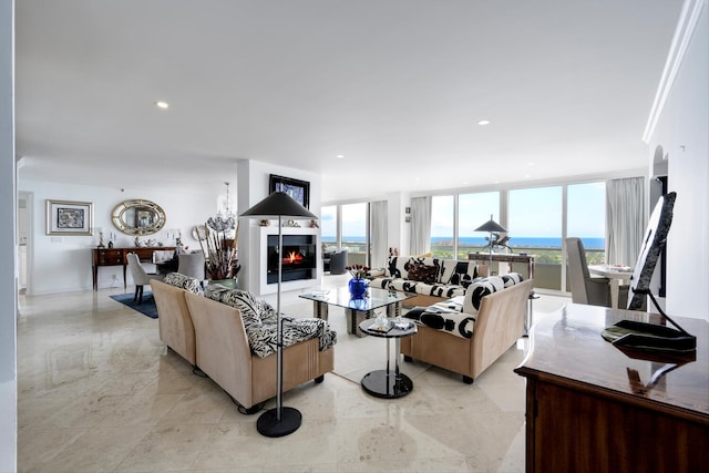 living room featuring ornamental molding, a wall of windows, and a water view