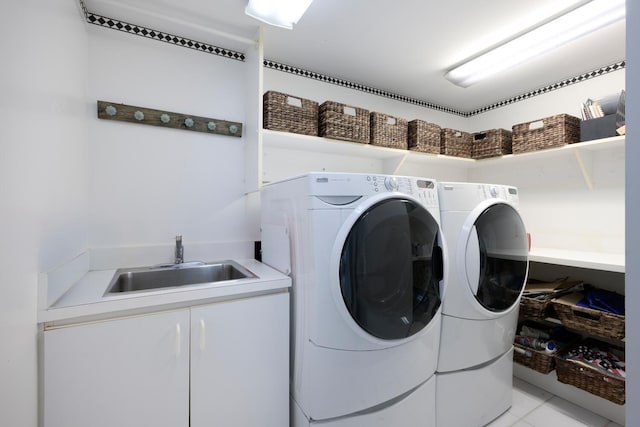 laundry area featuring cabinets, sink, washer and clothes dryer, and light tile patterned floors