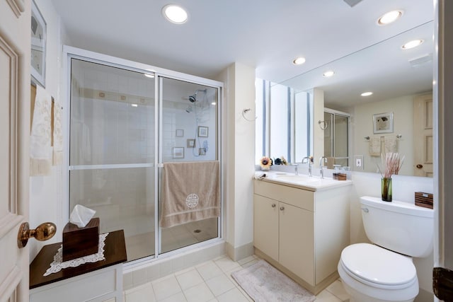 bathroom featuring vanity, toilet, tile patterned flooring, and a shower with door