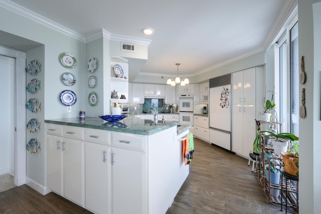 kitchen featuring built in appliances, dark wood-type flooring, and white cabinets