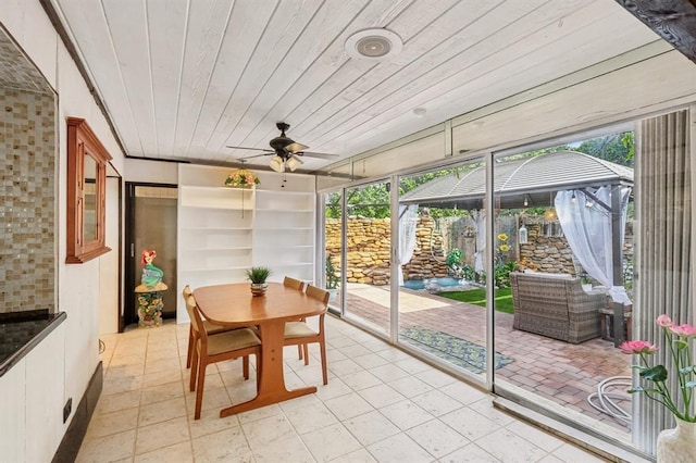 sunroom with ceiling fan and wooden ceiling