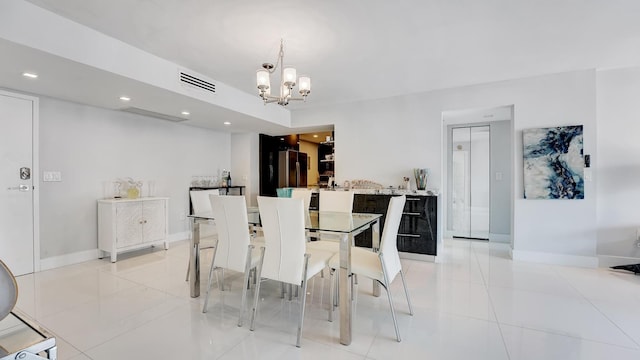 tiled dining area featuring a notable chandelier