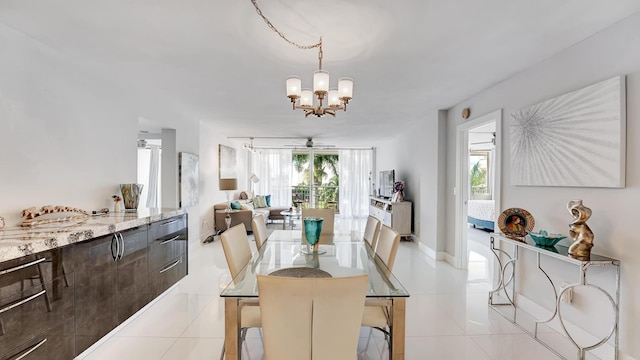 tiled dining area with ceiling fan with notable chandelier