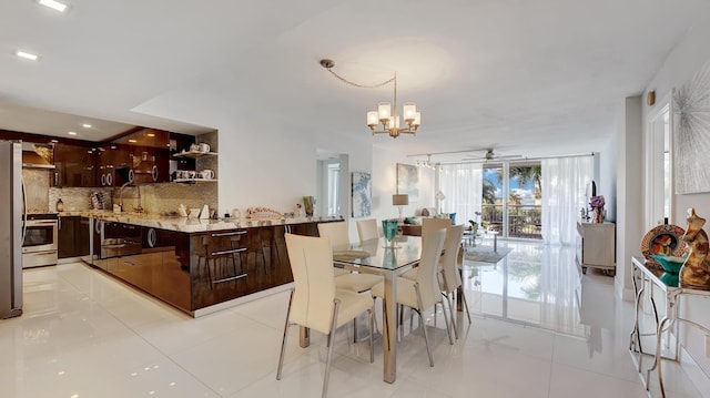 tiled dining area with ceiling fan with notable chandelier