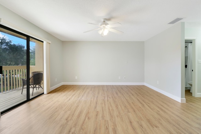 empty room with a textured ceiling, light wood-type flooring, and ceiling fan