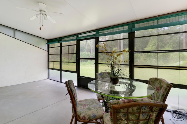 unfurnished sunroom with ceiling fan