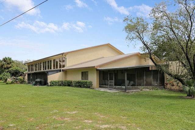 back of house featuring a yard and a sunroom