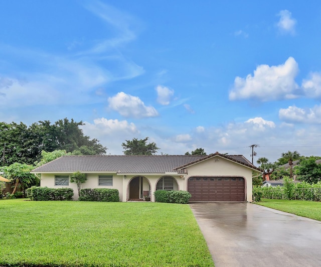 single story home featuring a garage and a front lawn